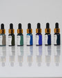 Aqua Pigments Collection: los siete pigmentos líquidos de tonos azules y verdes en fila sobre fondo blanco