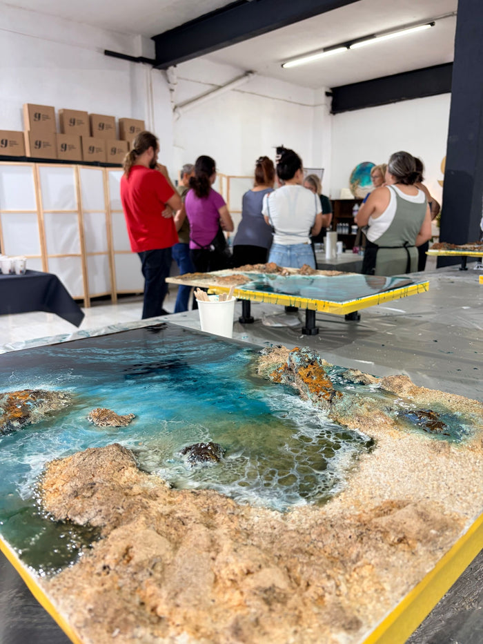 Obra grande de Ocean Art sobre la mesa del taller, con las alumnas al fondo
